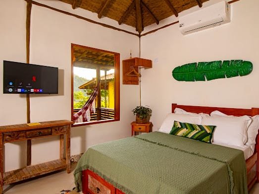 Quarto do bangalô com TV e ar-condicionado em Paraty
